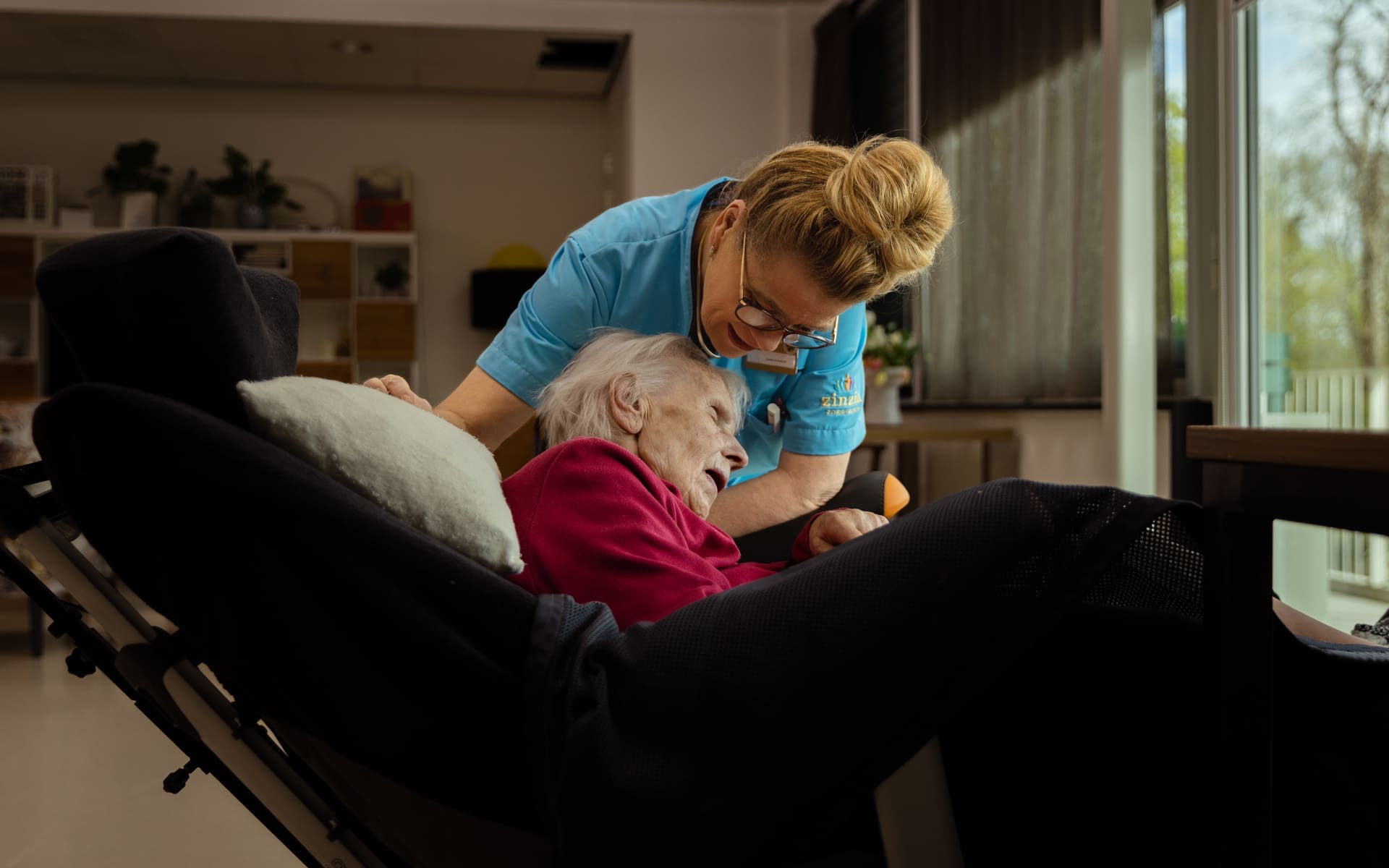 Vrouw die een cliënt helpt in haar bed